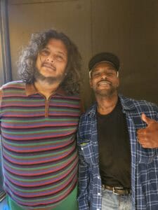 guy in a striped shirt poses with guy in a flannel